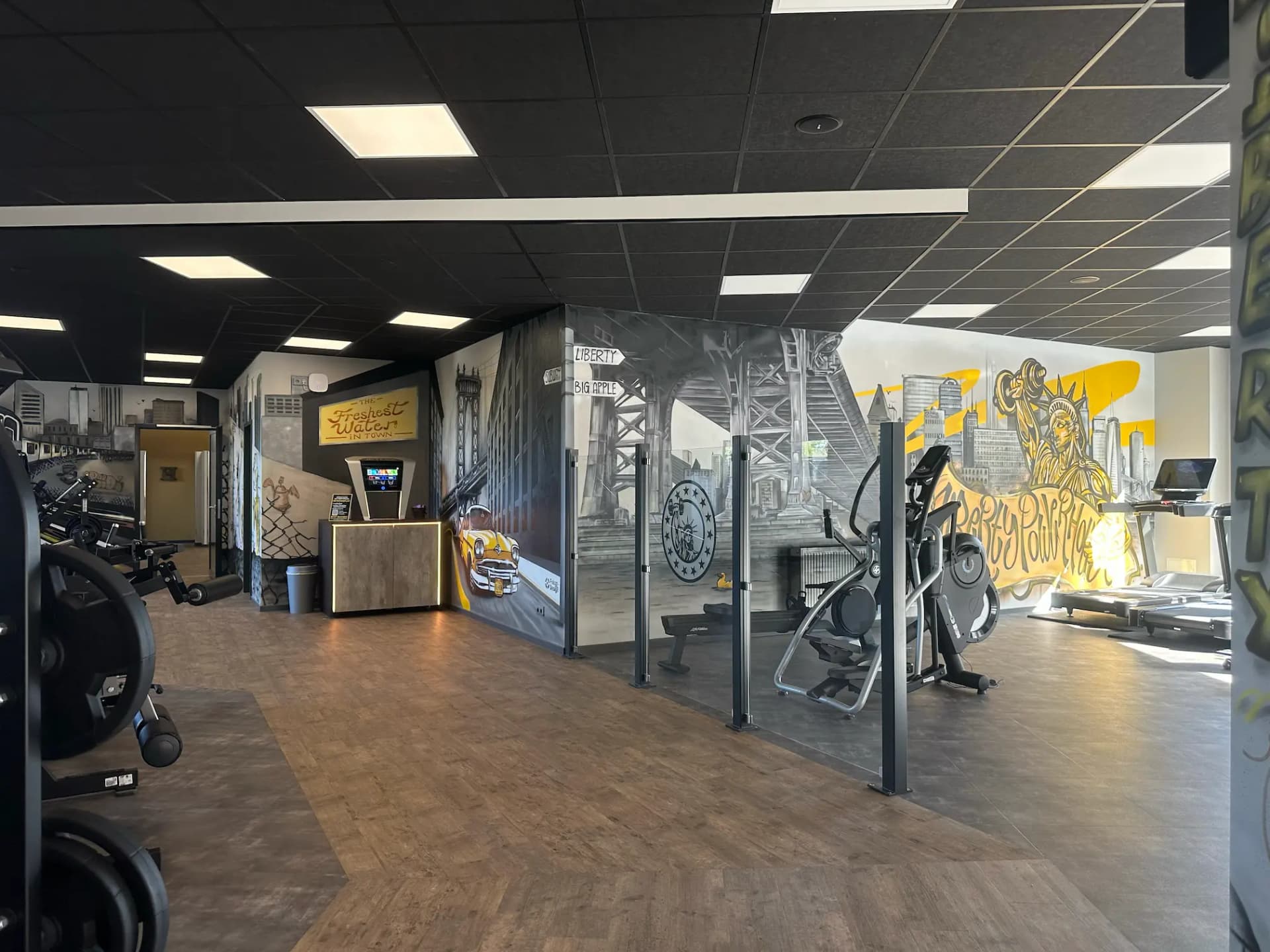 Exklusives Ambiente im Liberty Powerhouse Gym Michendorf mit dunkler Holz-Laufbahn und Functional Area.